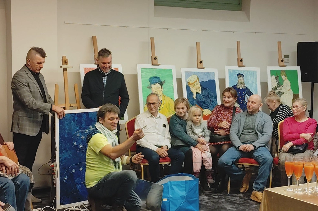 Zdjęcie grupowe uczestników warsztatów o zróżnicowanych potrzebach, w tym osoby z psem przewodnikiem, rozmawiających o dziele sztuki.